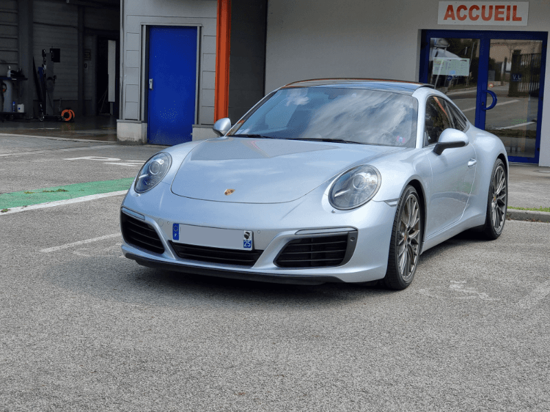 Porsche 911 grise devant le centre