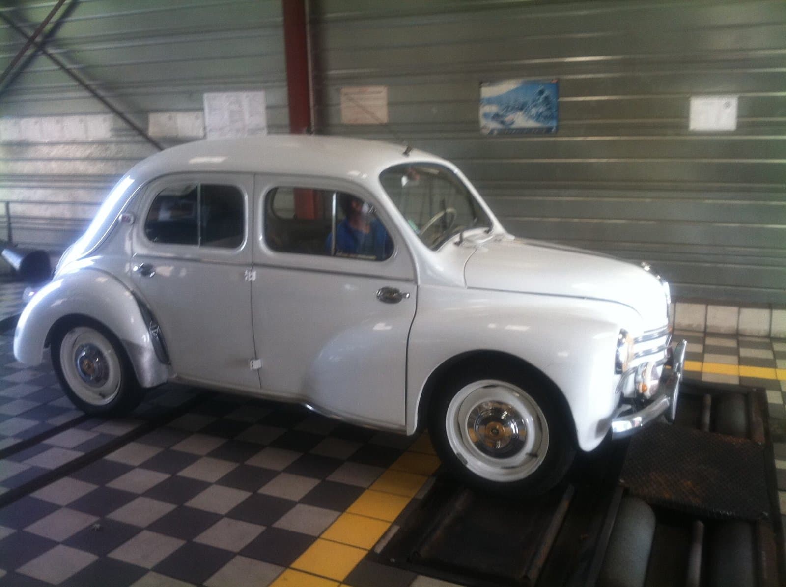 Renault 4CV blanche dans le garage de contrôle