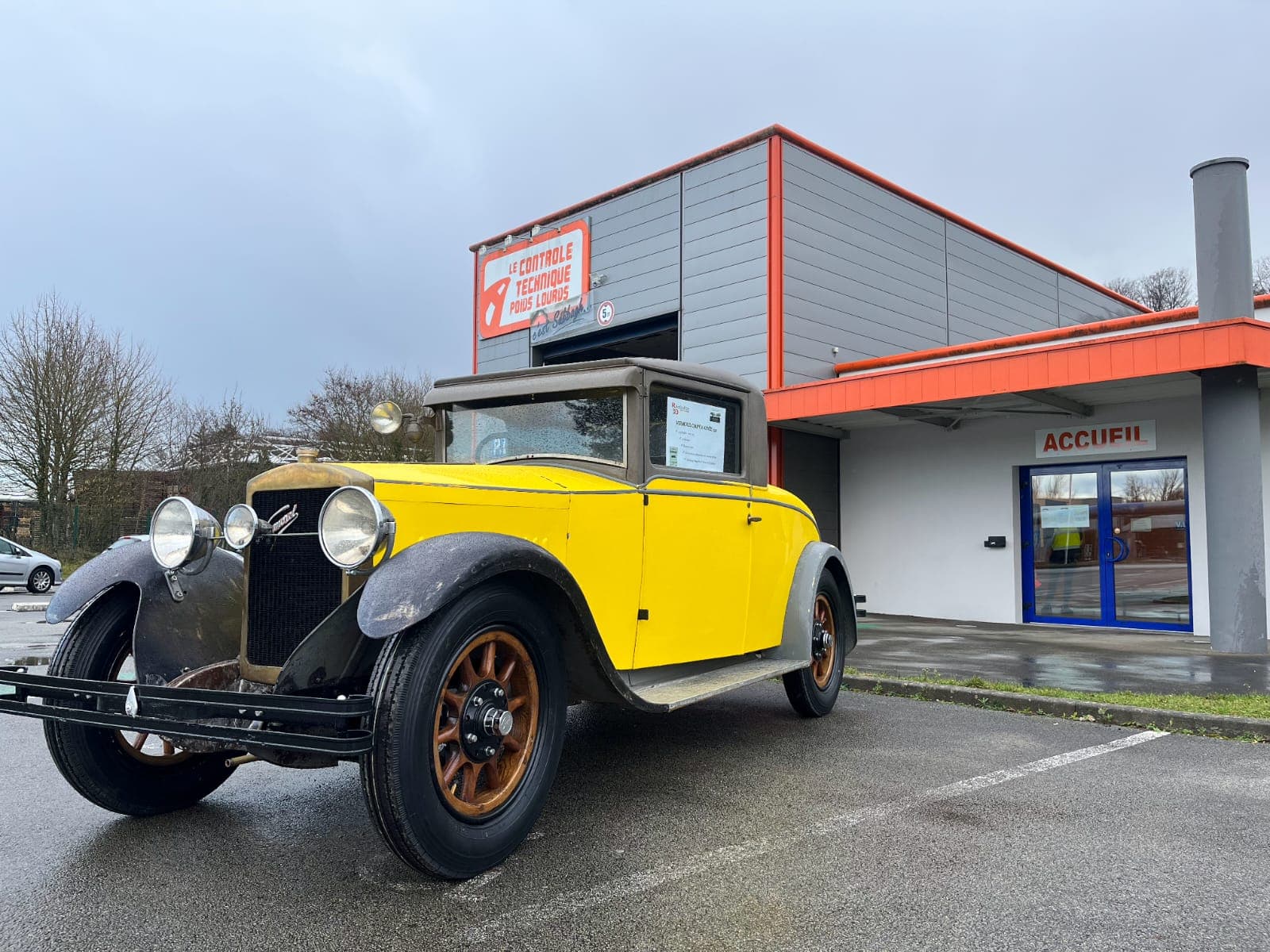 Voiture ancienne jaune et noire années 1920 devant le centre CTPLT