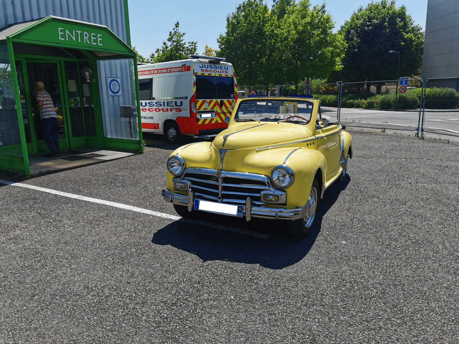 Peugeot 203 cabriolet jaune sur le parking du centre