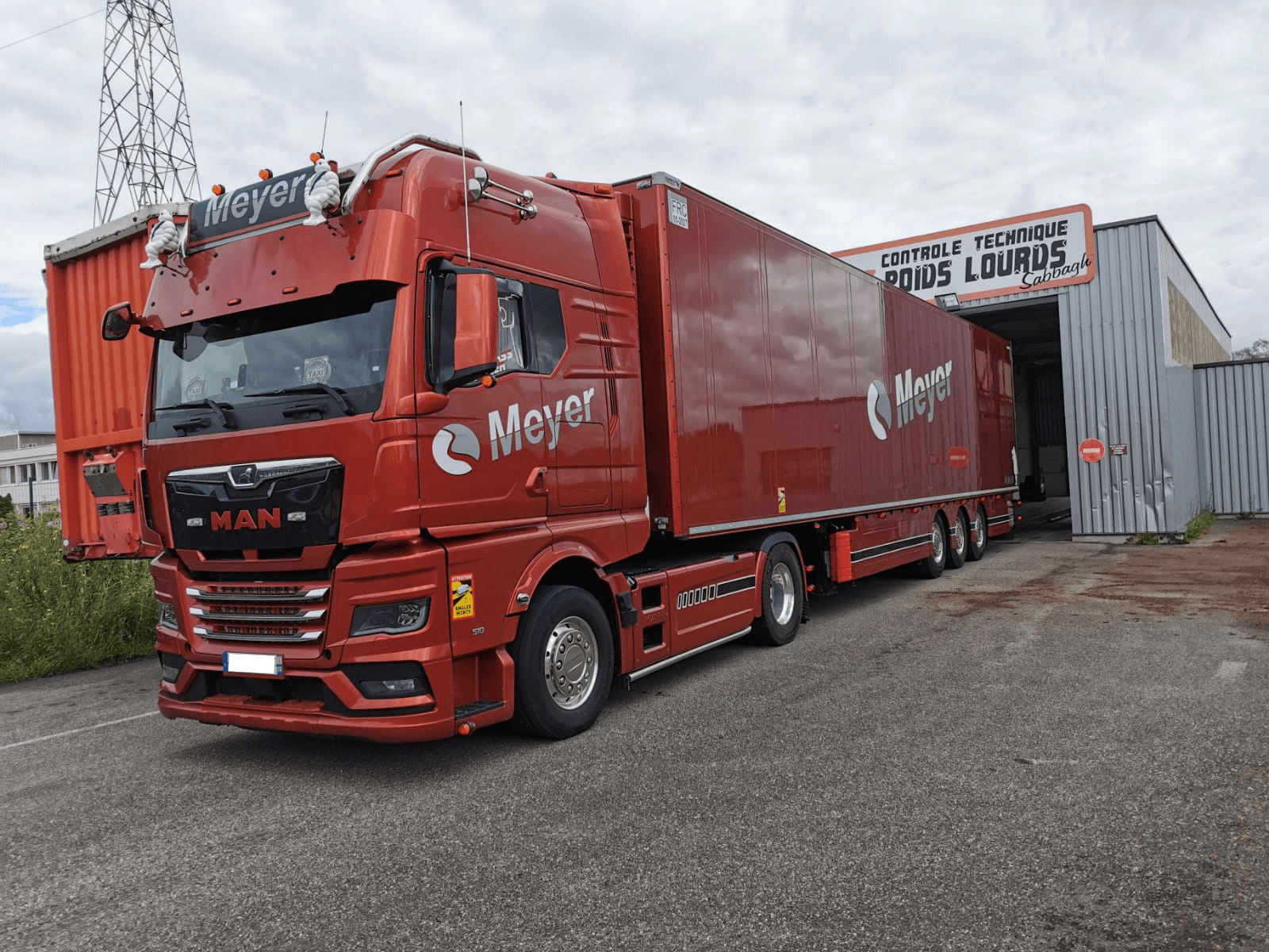 MAN TGX rouge semi-remorque Meyer au centre poids lourds